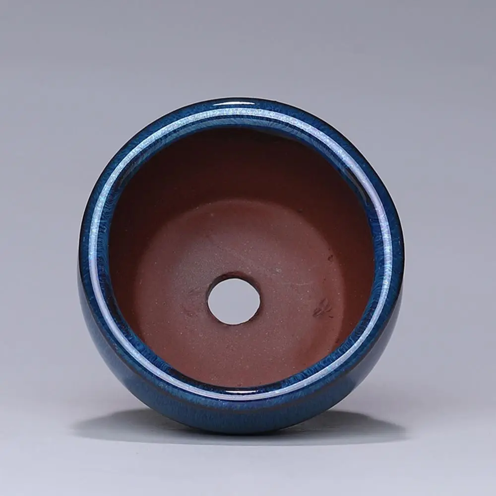 Blau glänzender Topf in Keramik-Optik, Blick von oben auf das rotbraune Innere