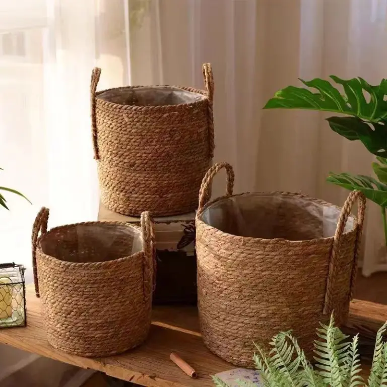Geflochtener Übertopf in Naturfarbe mit zwei Henkeln, Pflanze und Buch auf einem Tisch